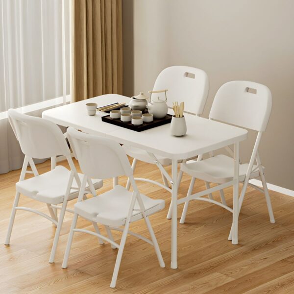 White foldable plastic chair set up in a bright outdoor setting, showcasing its sleek design and lightweight structure.