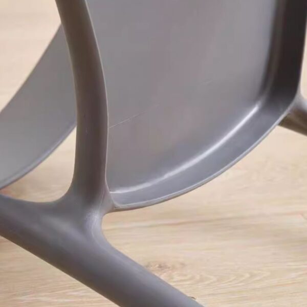 Bseak Plastic Dining Chair in a modern dining room setting, showcasing its sleek design and vibrant color options.